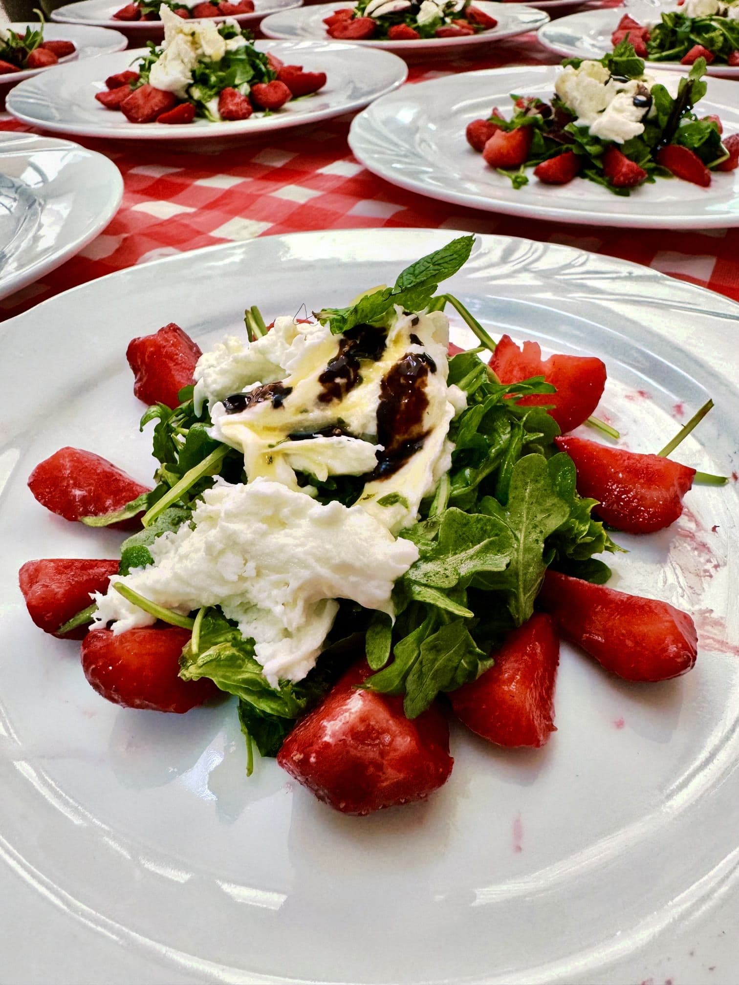 Angerichteter Teller mit Erdbeeren, Burrata und Rucola