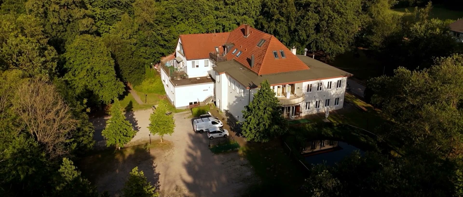 Die Habichtshöhe von oben: das weiße Haus mit rotem Dach, ringsum der Wald