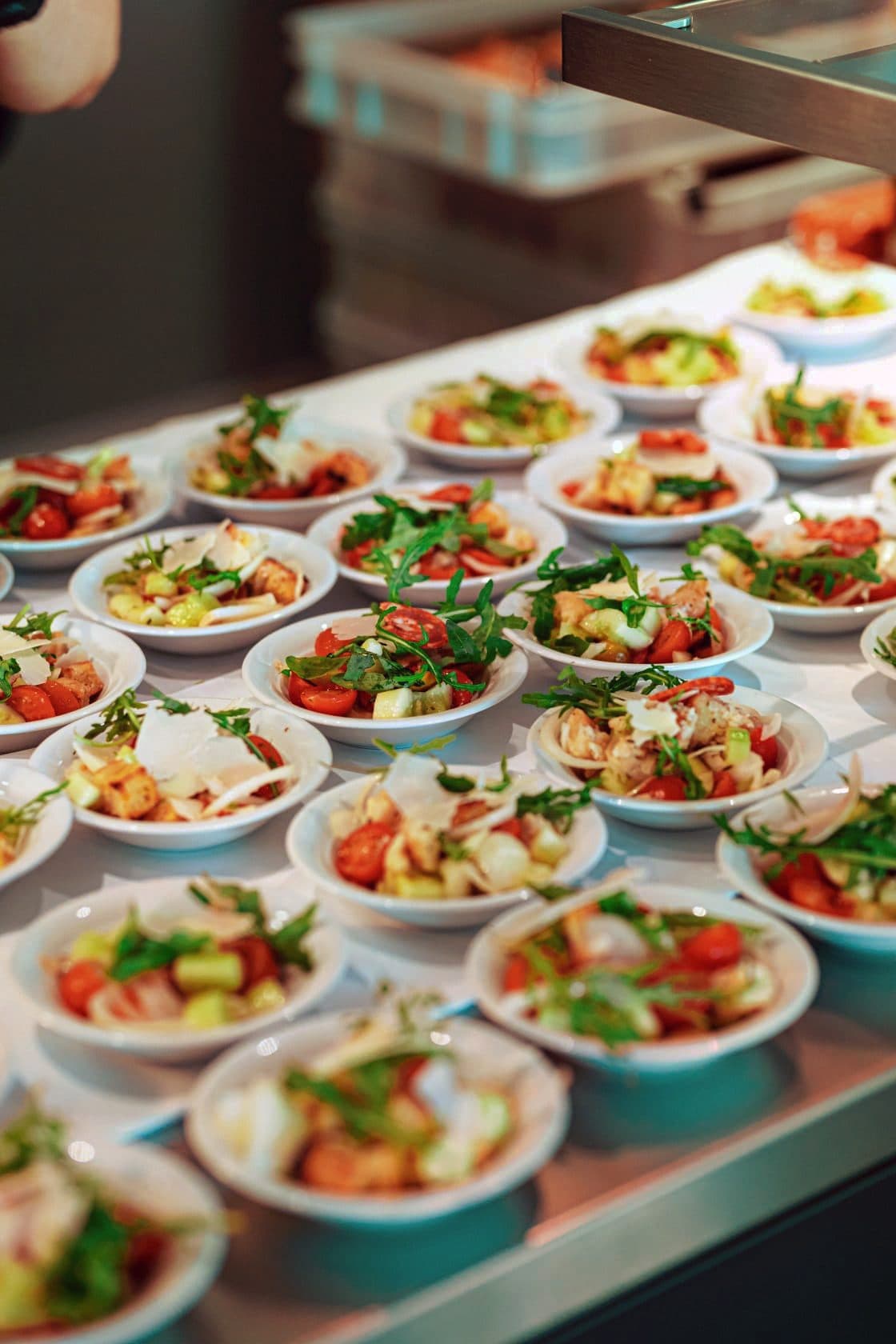 Reihen kleiner Vorspeisenschalen mit Brotsalat auf der Buffettafel