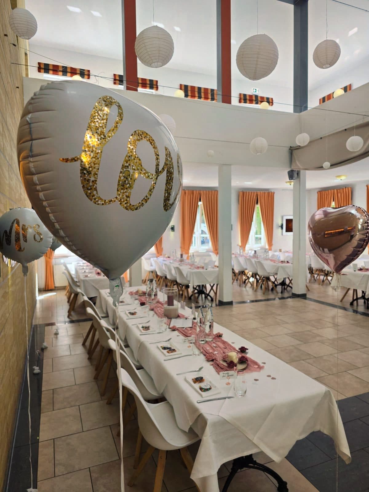 Love-Ballon über der festlich gedeckten Tafel im Saal